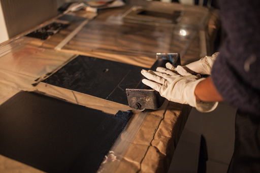 Image showing someone rolling ink for lithographs, part of the puzzle making process